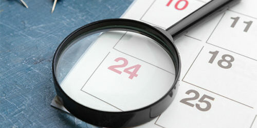 stock image of a magnifying glass over a calendar